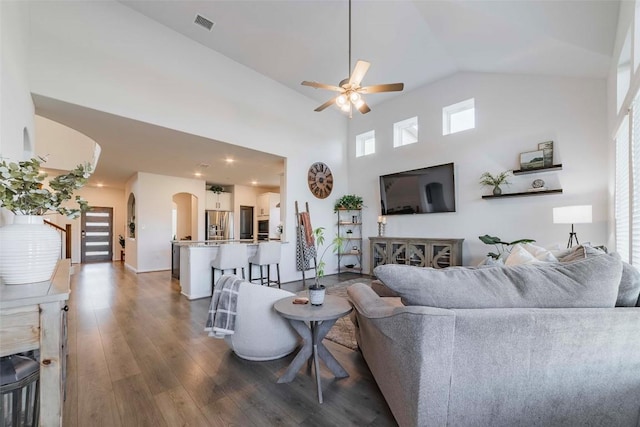 living room featuring dark wood-type flooring, high vaulted ceiling, and ceiling fan