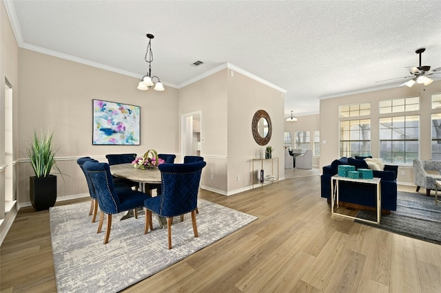 dining room featuring crown molding, light hardwood / wood-style flooring, and a textured ceiling