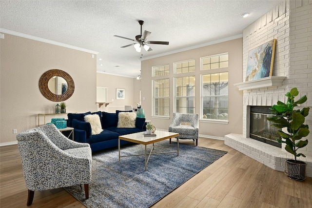 living room with hardwood / wood-style floors, crown molding, a fireplace, and a textured ceiling