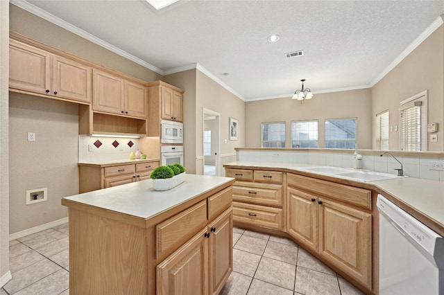 kitchen featuring sink, white appliances, backsplash, hanging light fixtures, and a kitchen island