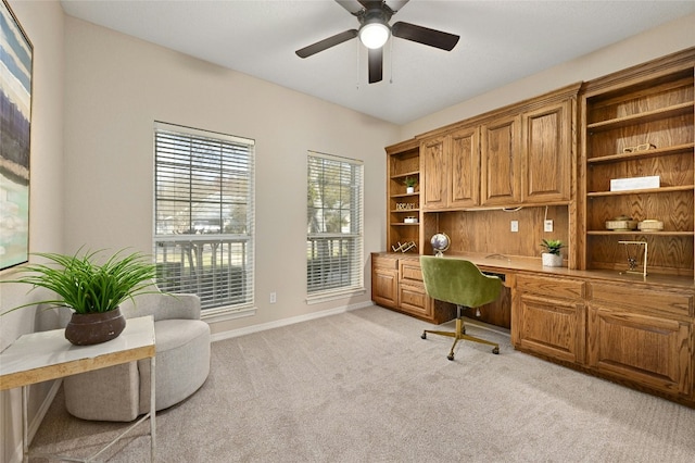 carpeted office with built in desk and ceiling fan