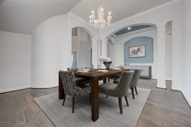 dining space with an inviting chandelier, ornamental molding, hardwood / wood-style floors, and decorative columns