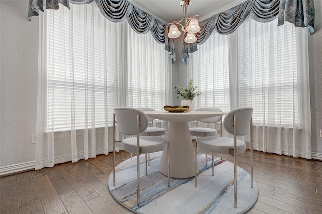 dining area with hardwood / wood-style flooring and a chandelier