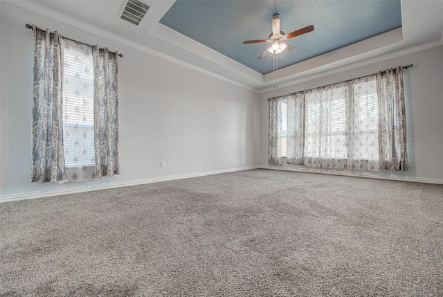 spare room featuring ornamental molding, carpet flooring, ceiling fan, and a tray ceiling