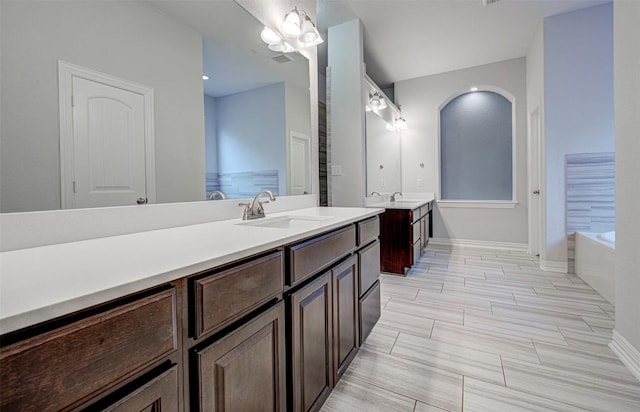 bathroom featuring vanity and a washtub