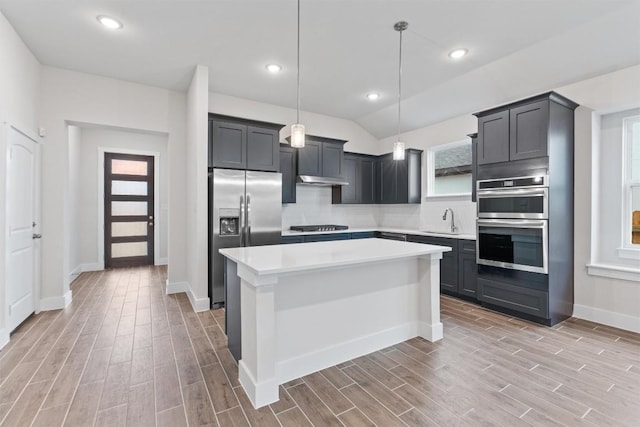 kitchen with sink, tasteful backsplash, decorative light fixtures, a center island, and appliances with stainless steel finishes