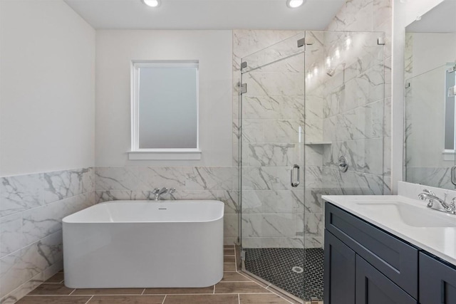 bathroom featuring vanity, independent shower and bath, and tile walls