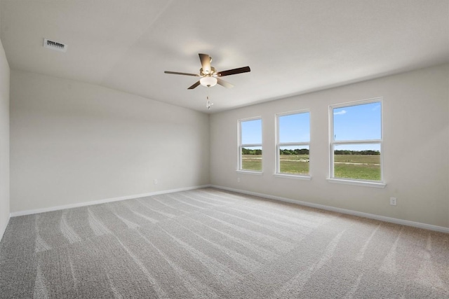 empty room with a ceiling fan, baseboards, carpet floors, and visible vents