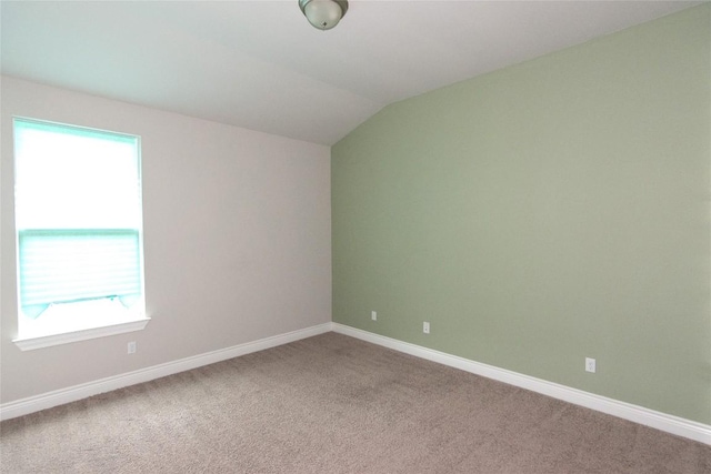 unfurnished room featuring vaulted ceiling and carpet flooring