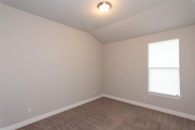 carpeted empty room featuring lofted ceiling