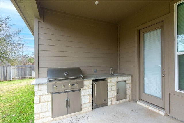 view of patio with an outdoor kitchen, a grill, and sink