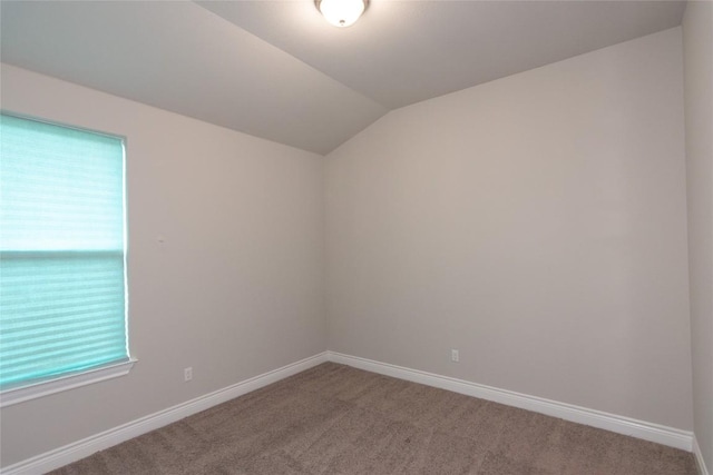 unfurnished room with vaulted ceiling and carpet