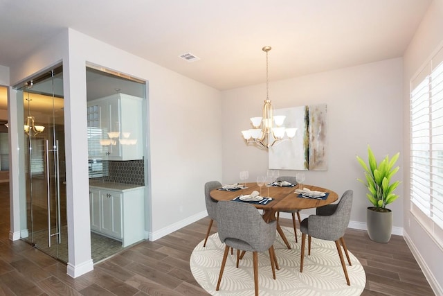 dining space featuring dark hardwood / wood-style flooring, plenty of natural light, and a chandelier