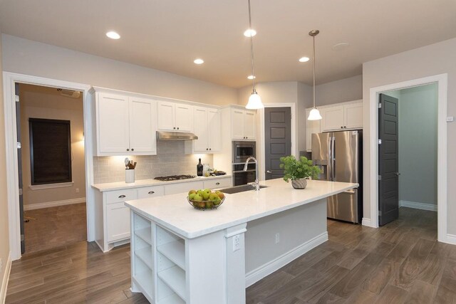 kitchen featuring pendant lighting, stainless steel appliances, a kitchen island with sink, and white cabinets