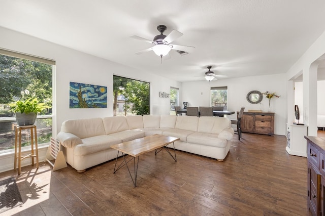 living room featuring ceiling fan, dark hardwood / wood-style flooring, and a wealth of natural light