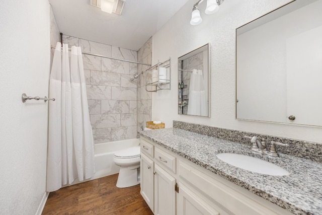 full bathroom featuring vanity, hardwood / wood-style floors, shower / tub combo, and toilet