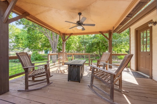 wooden deck featuring ceiling fan and an outdoor fire pit