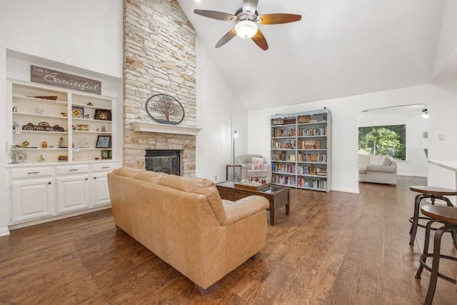 living room featuring ceiling fan, a fireplace, dark hardwood / wood-style flooring, and high vaulted ceiling