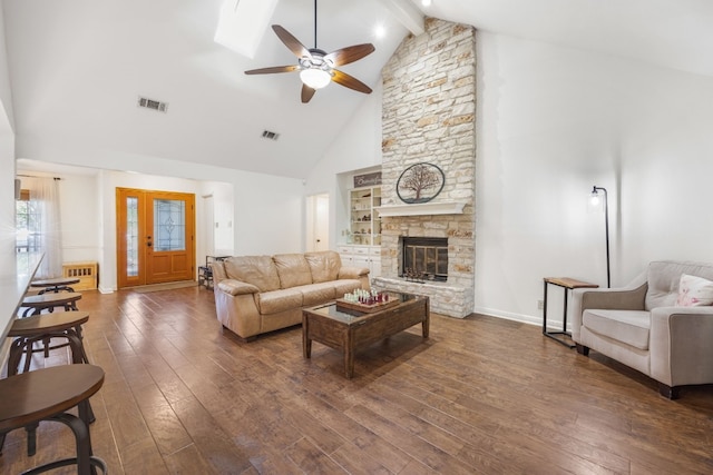 living room with a stone fireplace, high vaulted ceiling, beamed ceiling, ceiling fan, and dark wood-type flooring