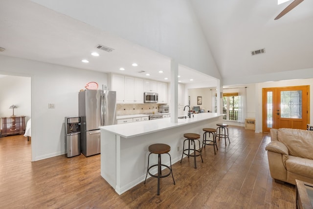 kitchen with sink, a breakfast bar area, white cabinetry, a kitchen island with sink, and stainless steel appliances