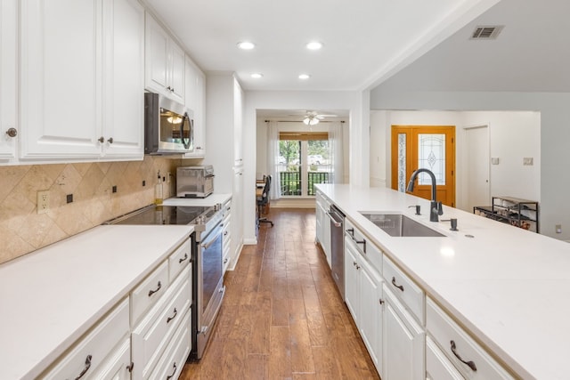 kitchen featuring white cabinetry, sink, decorative backsplash, hardwood / wood-style flooring, and stainless steel appliances