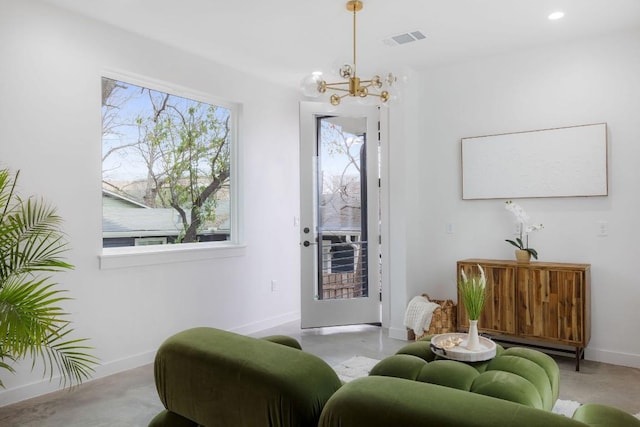 sitting room featuring a wealth of natural light and an inviting chandelier