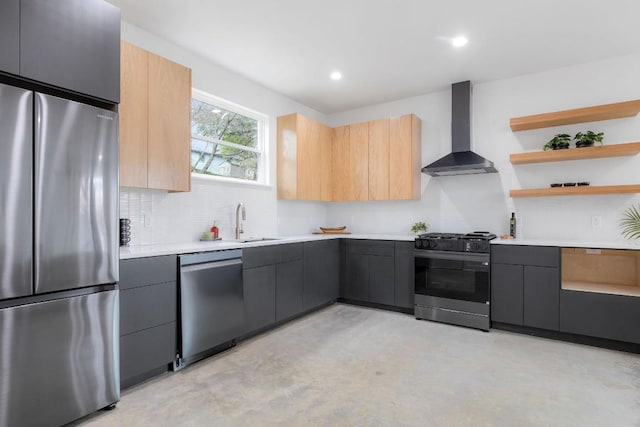 kitchen featuring sink, gray cabinetry, appliances with stainless steel finishes, wall chimney range hood, and backsplash