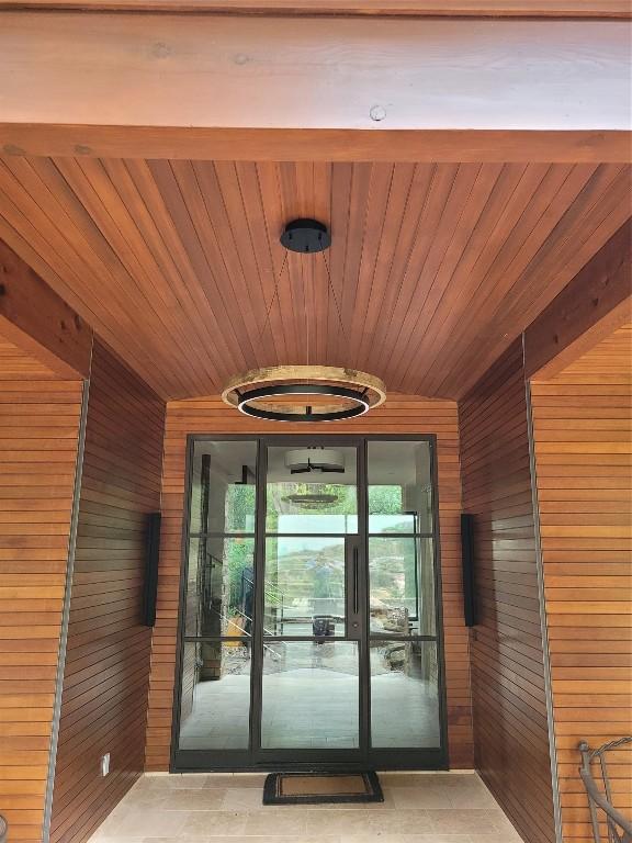 doorway with wooden walls and wooden ceiling