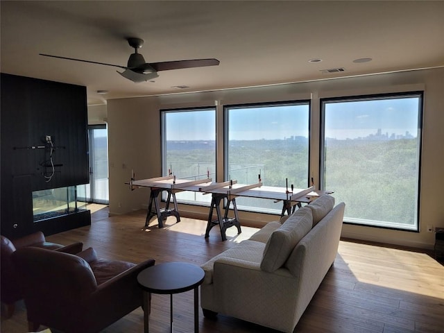 living room featuring wood-type flooring, a mountain view, and a healthy amount of sunlight