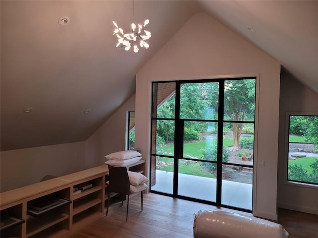 additional living space featuring a wealth of natural light, lofted ceiling, hardwood / wood-style floors, and a chandelier