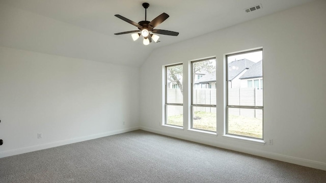 unfurnished room featuring ceiling fan, visible vents, baseboards, vaulted ceiling, and carpet