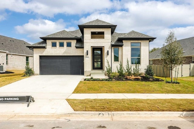 prairie-style house with a front yard, brick siding, driveway, and an attached garage