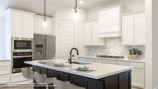 kitchen with stainless steel appliances, hanging light fixtures, light countertops, and white cabinets