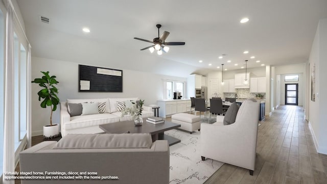 living area with a healthy amount of sunlight, light wood finished floors, visible vents, and recessed lighting