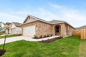 view of front of property with an attached garage, driveway, a front lawn, and fence