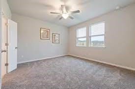 spare room with carpet floors, ceiling fan, and baseboards