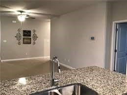 kitchen with ceiling fan, light stone counters, and a sink