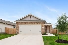 view of front facade with driveway, an attached garage, fence, and a front yard