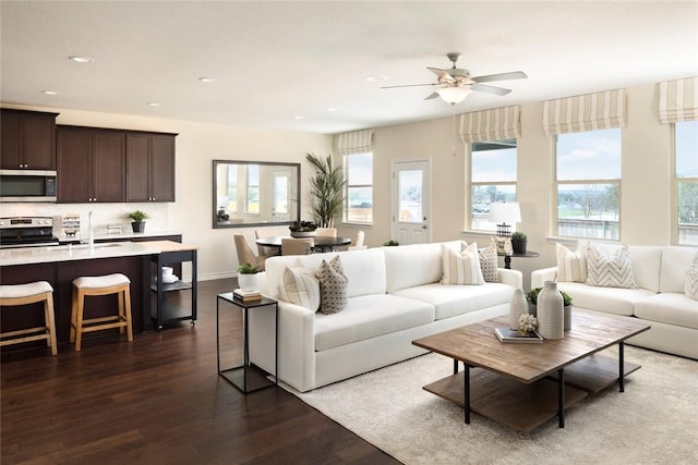 living room with ceiling fan, sink, and dark hardwood / wood-style flooring