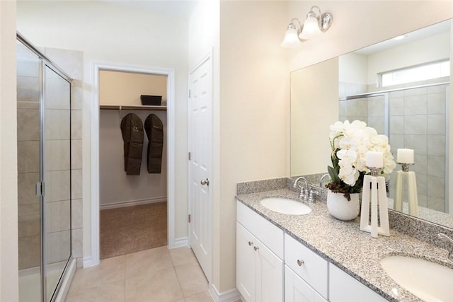 bathroom with tile patterned flooring, vanity, and a shower with door