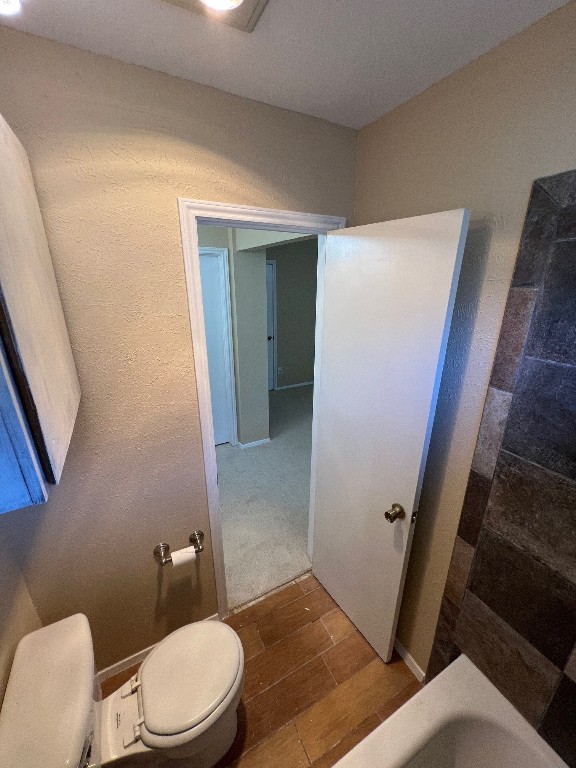 bathroom with toilet and a bathing tub