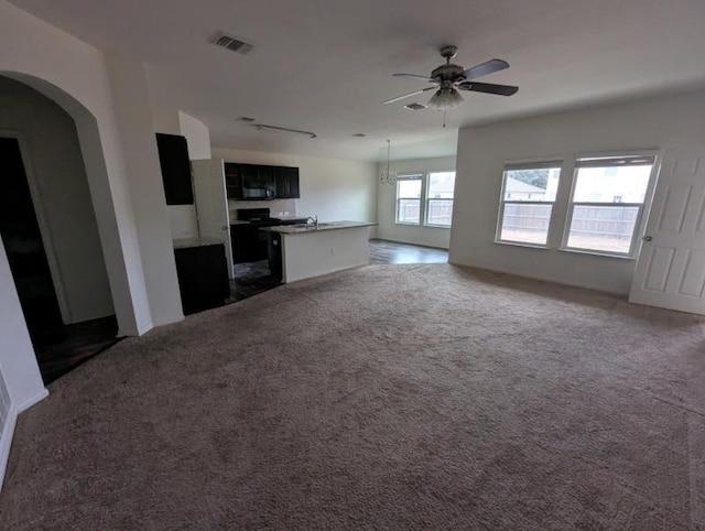 unfurnished living room with ceiling fan and dark carpet