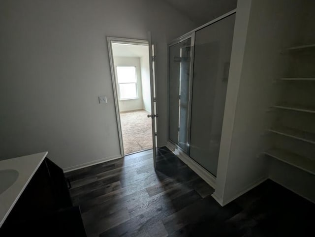 bathroom with a shower with door, vanity, and hardwood / wood-style flooring