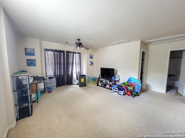 interior space featuring ceiling fan and light carpet