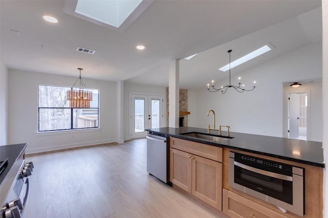 kitchen with sink, an inviting chandelier, appliances with stainless steel finishes, pendant lighting, and a healthy amount of sunlight