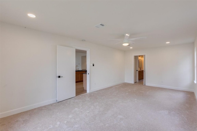 spare room featuring light colored carpet and ceiling fan