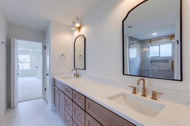 bathroom with vanity and a tile shower