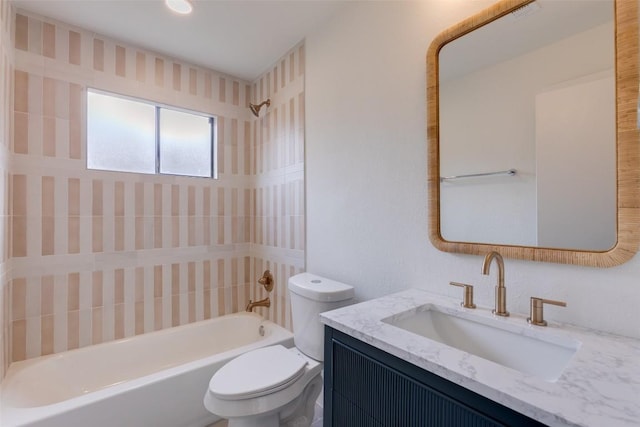 full bathroom featuring tiled shower / bath combo, vanity, and toilet