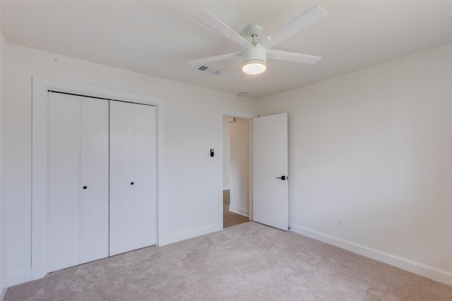 unfurnished bedroom with light carpet, a closet, and ceiling fan