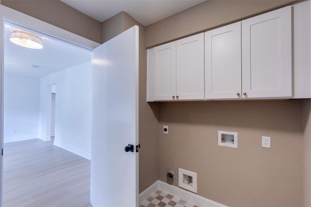 washroom featuring electric dryer hookup, washer hookup, light hardwood / wood-style flooring, and cabinets